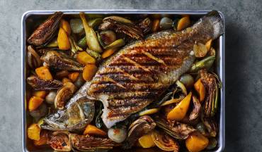 דג ברמונדי ישראלי שלם בתנור עם ארטישוק, גזרים ושומר ברוטב יין לבן